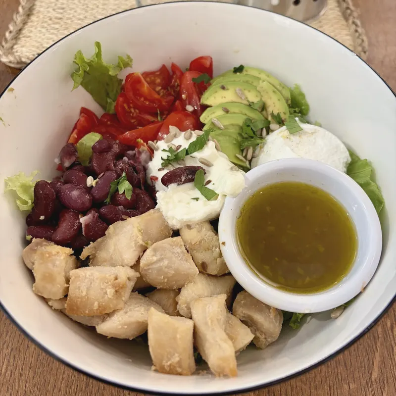 Chicken bean salad with avocado, red beans, yogurt and a pot of dressing
